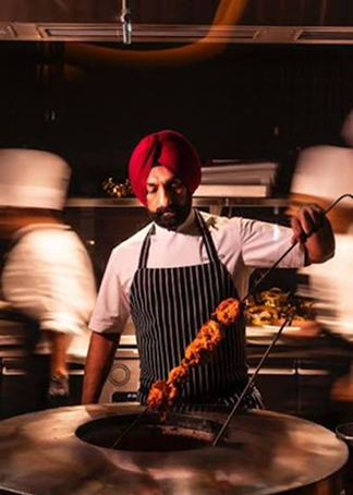 Chef Surjan Singh in a white chef coat with arms crossed